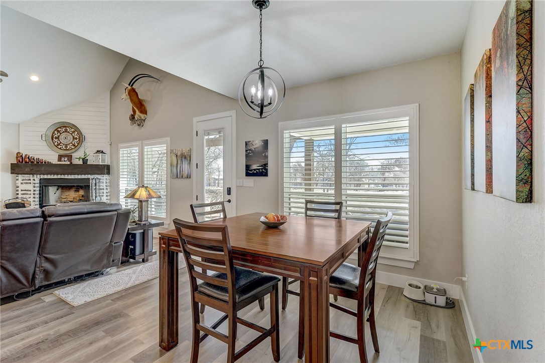 281 Cibolo Way La Vernia, TX 78121 - Photo 14 of 47 a dining room with wooden floor a chandelier a wooden table and chairs