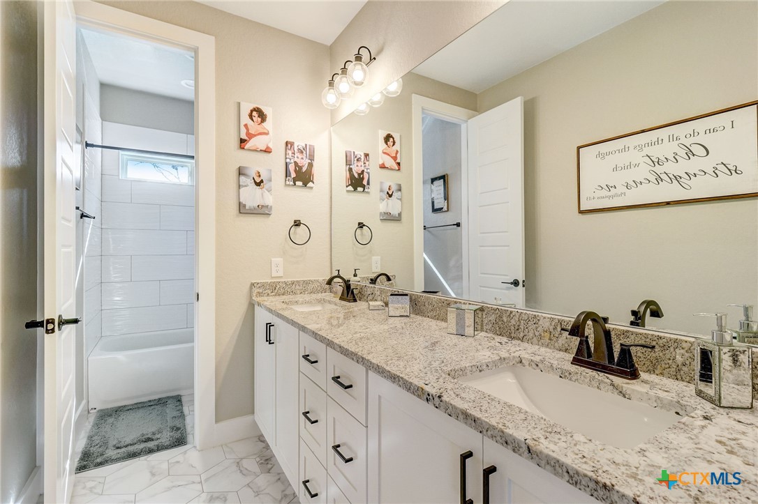 281 Cibolo Way La Vernia, TX 78121 - Photo 30 of 47 a bathroom with a granite countertop sink mirror and shower