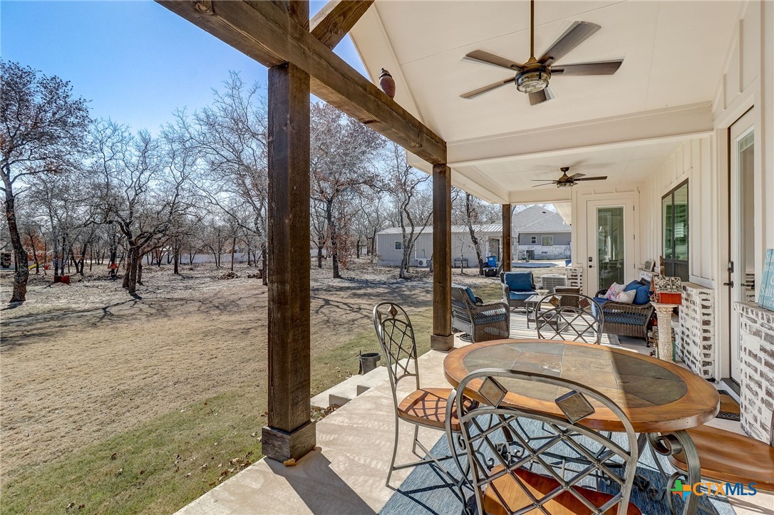 281 Cibolo Way La Vernia, TX 78121 - Photo 38 of 47 a view of a patio with dining table and chairs with wooden floor and fence