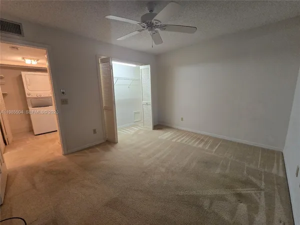 an empty room with windows and fan