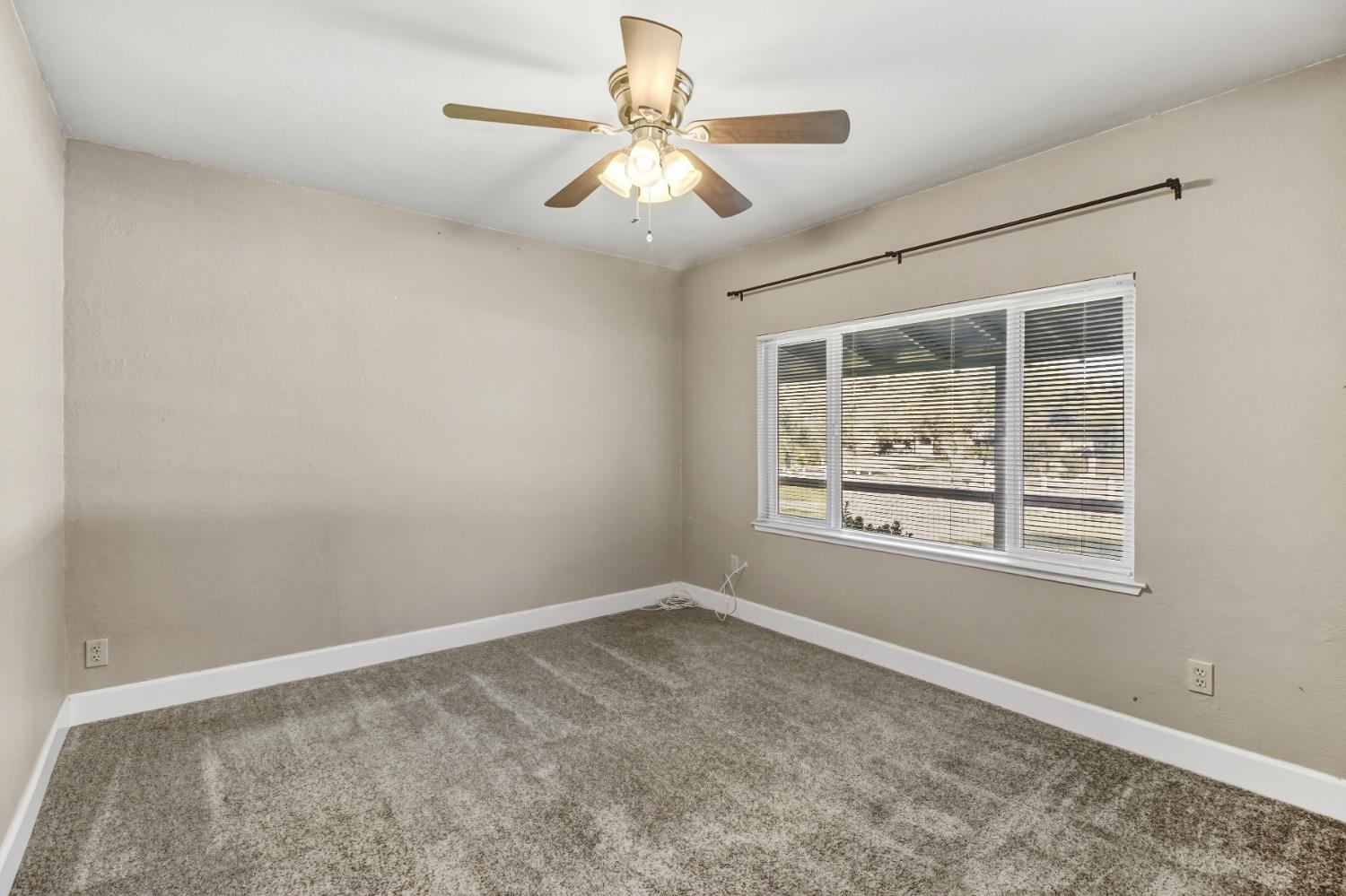 3140 Brennans Road Loomis, CA 95650 - Photo 10 of 45 an empty room with chandelier fan and windows