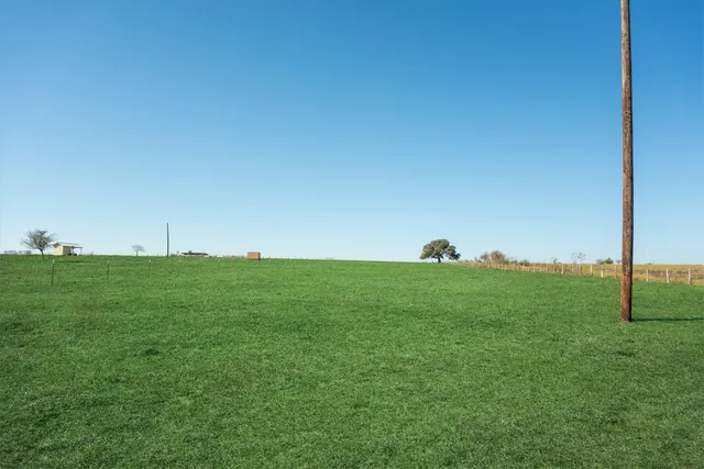 a view of field with grass and a fence