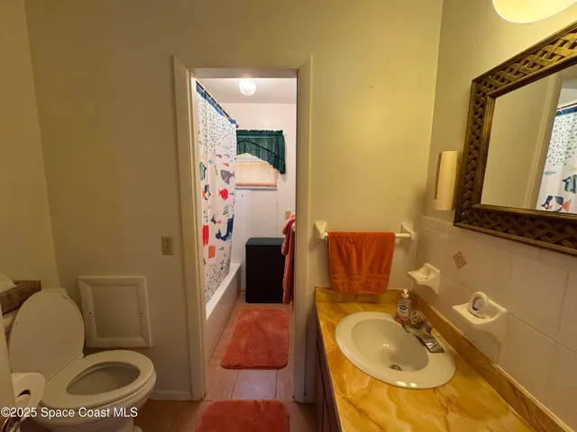 a bathroom with a granite countertop toilet sink and mirror