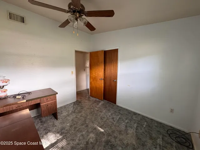 an empty room with windows and closet