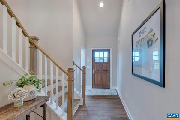a view of front door with wooden floor and stairs