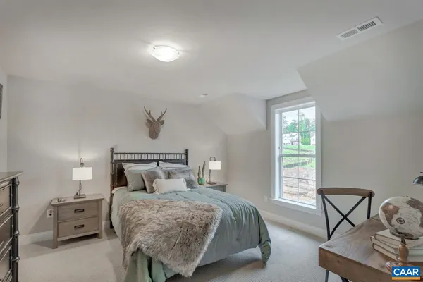 a bedroom with a bed a chair and next to a window