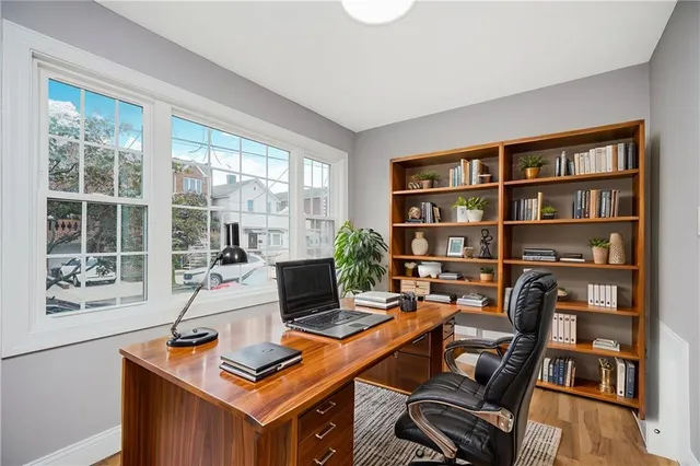 a work room with furniture bookshelf and a window