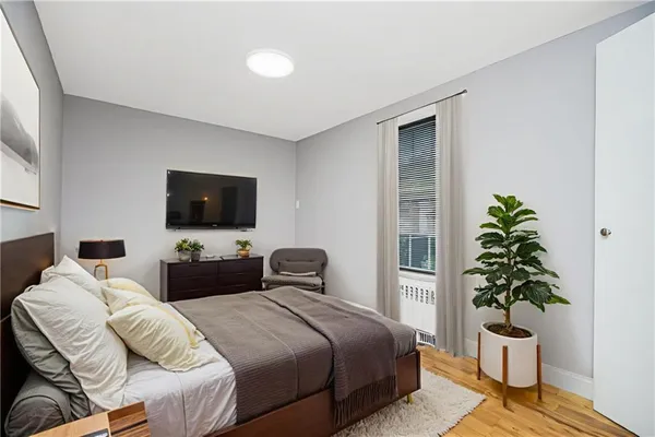 a bedroom with a bed and a potted plant