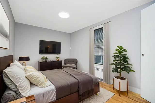 a bedroom with a bed and a potted plant