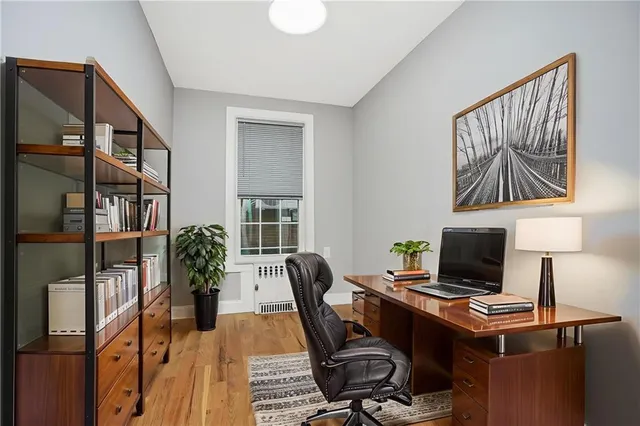 a view of a workspace with furniture and a window