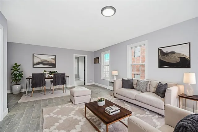a living room with furniture a rug and a window