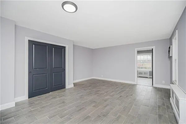 an empty room with wooden floor and closet