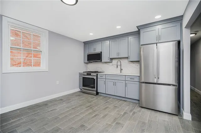 a kitchen with a refrigerator stove and wooden cabinets