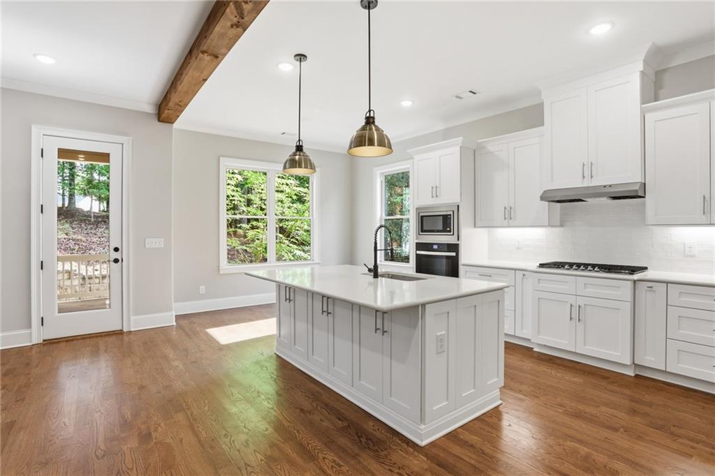 222 Trecastle Square, Unit 21 Canton, GA 30114 - Photo 12 of 33 a open kitchen with stainless steel appliances granite countertop a stove a sink dishwasher a refrigerator and a wooden floor