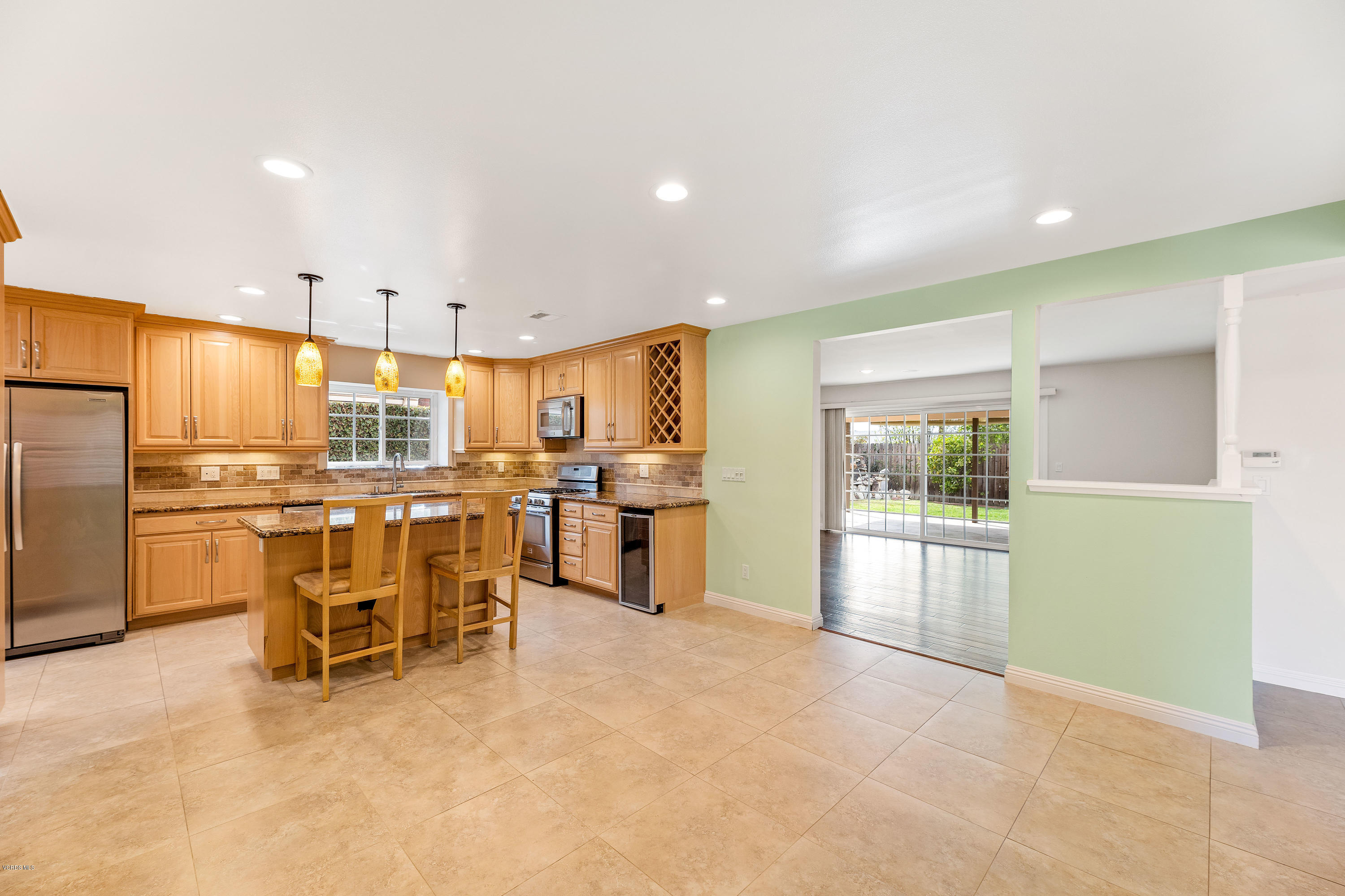 1049 Roldan Avenue Simi Valley, CA 93065 - Photo 4 of 26 a kitchen with stainless steel appliances kitchen island granite countertop a refrigerator and cabinets
