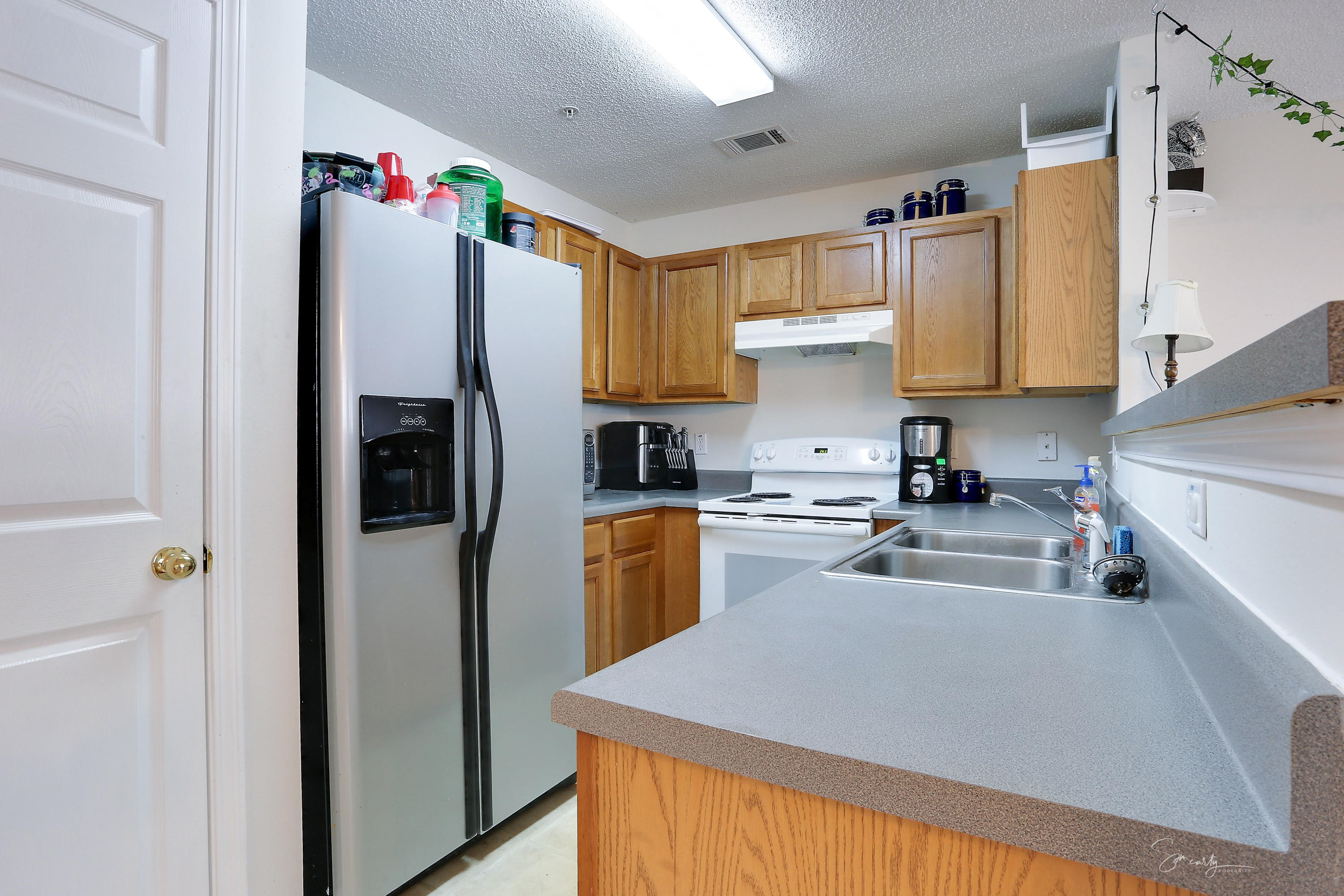 365 Crooked Pine Trail Crestview, FL 32539 - Photo 14 of 35 a kitchen with granite countertop a refrigerator a sink dishwasher and white cabinets with wooden floor