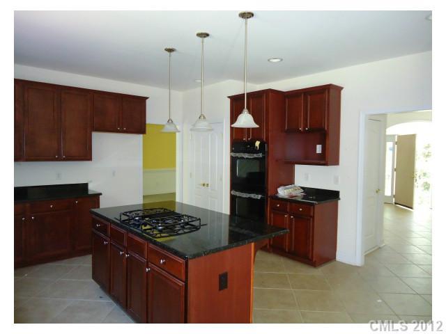 7123 Nesbit Road Waxhaw, NC 28173 - Photo 2 of 16 a kitchen with a stove a refrigerator and wooden cabinets