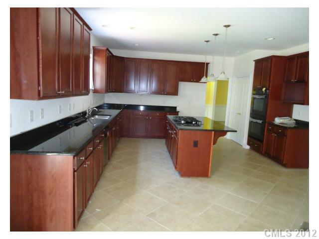 7123 Nesbit Road Waxhaw, NC 28173 - Photo 3 of 16 a kitchen with granite countertop a stove and a refrigerator