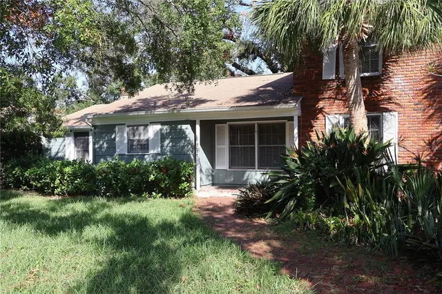a front view of a house with a yard and potted plants