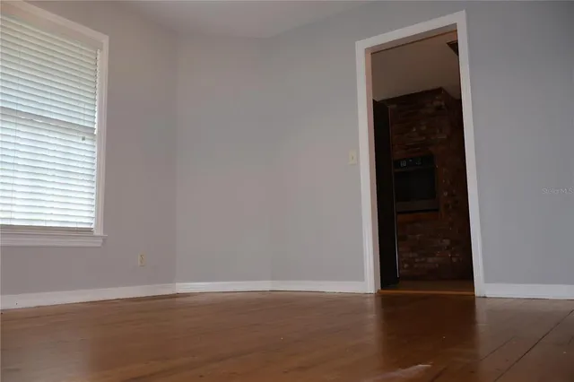 an empty room with wooden floor and closet