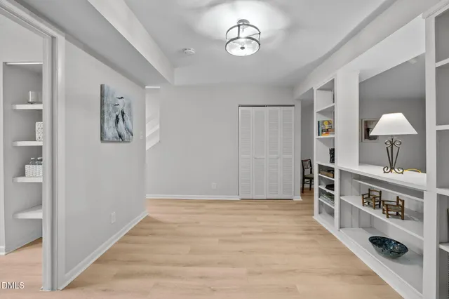 an empty room with windows and cabinet