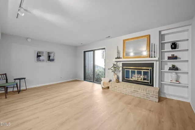an empty room with wooden floor and mirror
