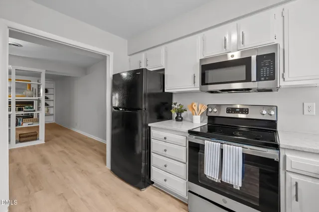 a kitchen with cabinets appliances a sink and a window