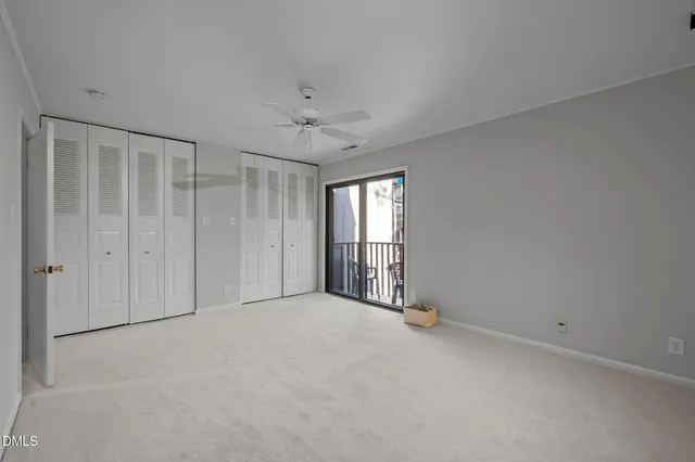 an empty room with windows and ceiling fan