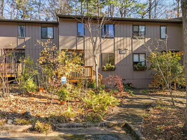 a view of a house with a small yard and potted plants