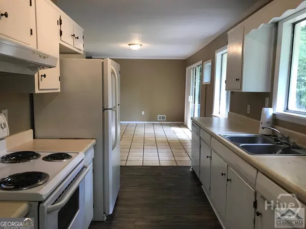 a kitchen with granite countertop a sink stove and refrigerator