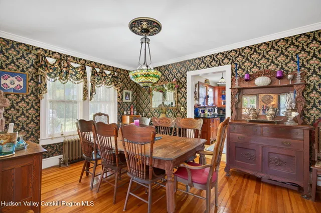 a view of a dining room with furniture a chandelier and wooden floor