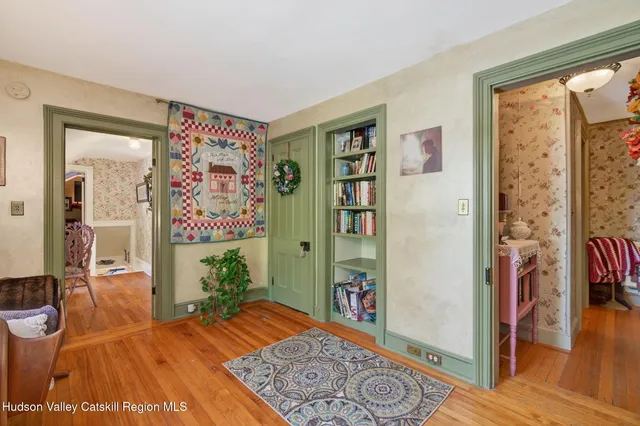 a room with painting on the wall and a potted plant
