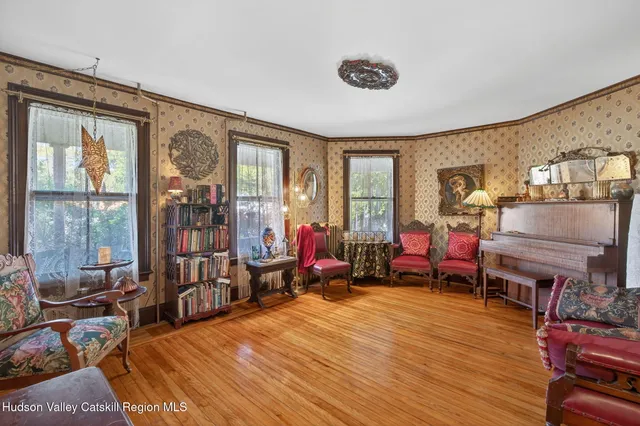 a living room with furniture a flat screen tv and a floor to ceiling window