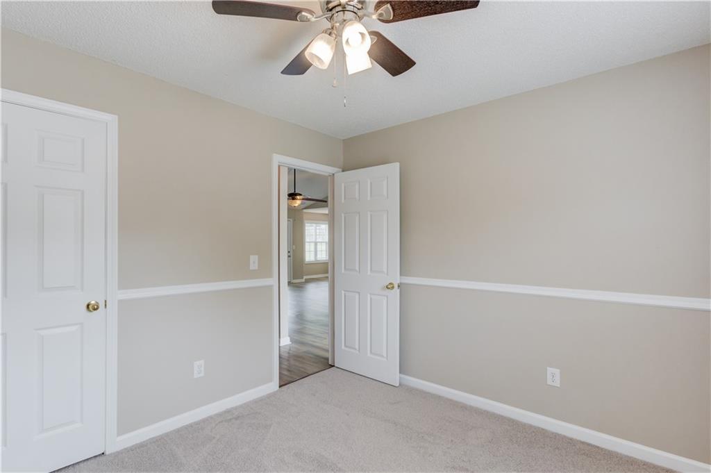 255 Turnberry Lane Winder, GA 30680 - Photo 25 of 41 an empty room with a chandelier fan
