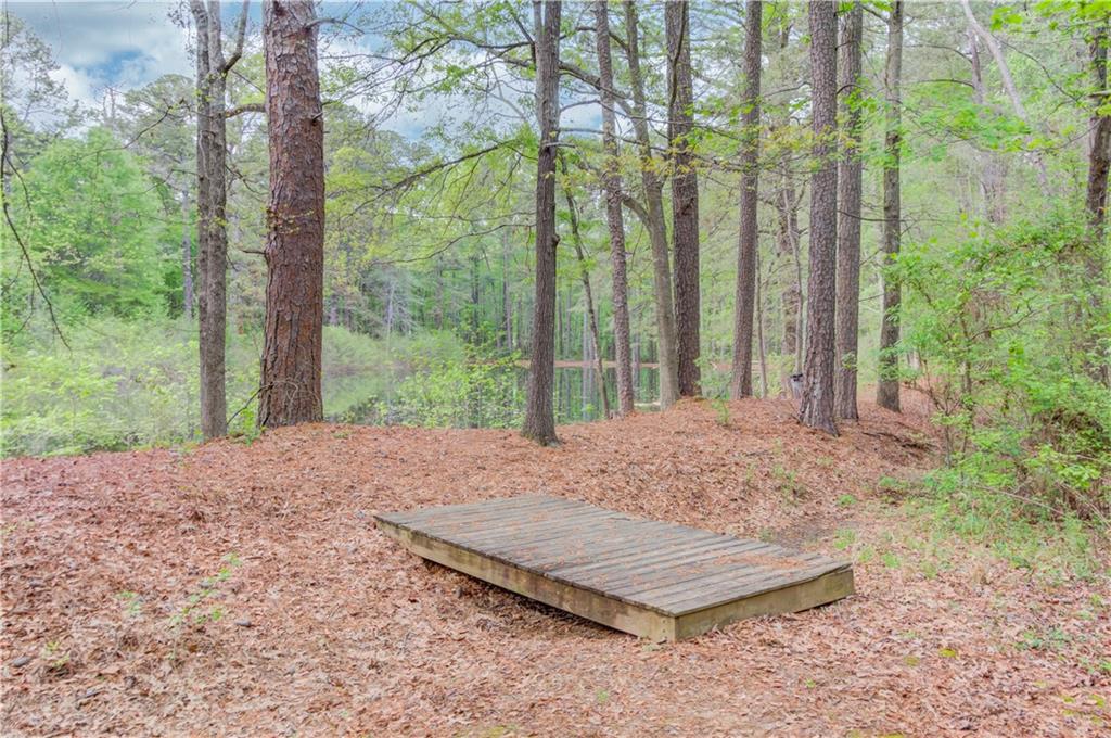 255 Turnberry Lane Winder, GA 30680 - Photo 40 of 41 a wooden bench sitting in middle of forest