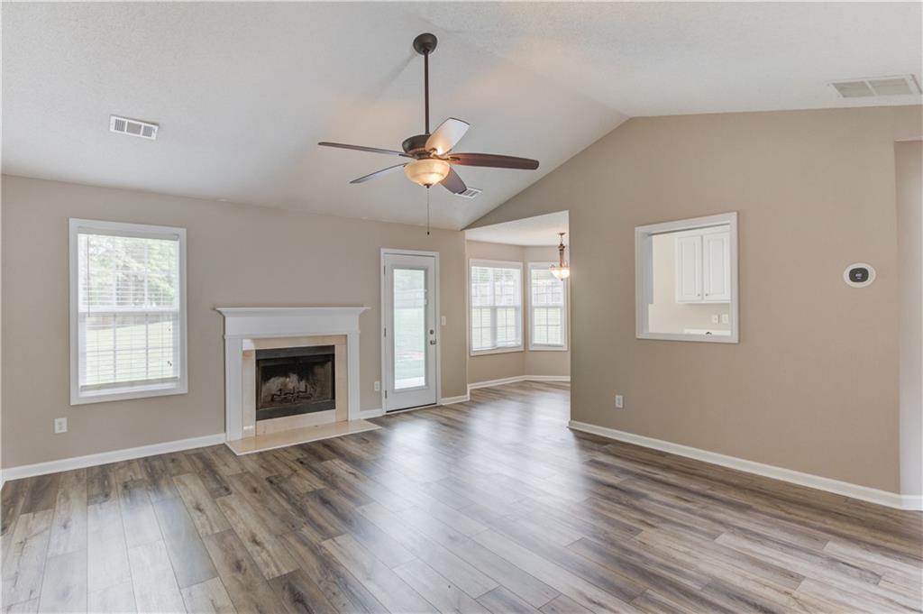255 Turnberry Lane Winder, GA 30680 - Photo 10 of 41 a view of an empty room with wooden floor fireplace and a window