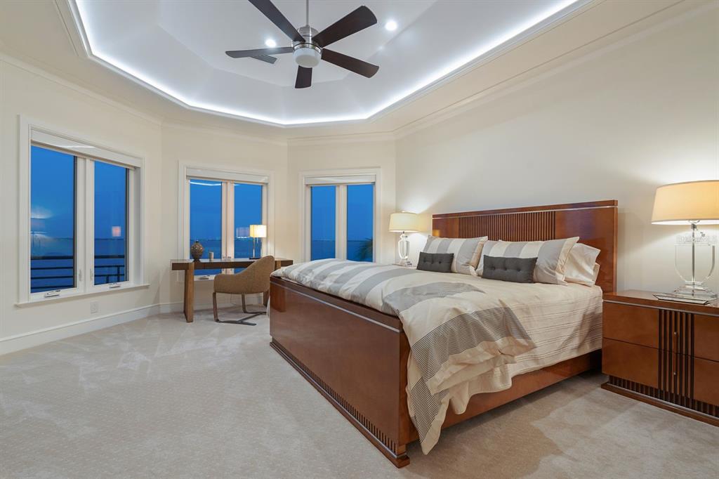 600 Putter Lane Longboat Key, FL 34228 - Photo 38 of 44 a spacious bedroom with a bed and a chandelier