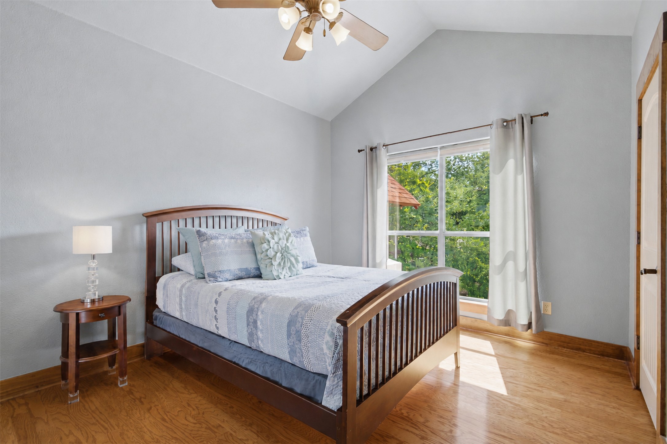 700 Augusta Circle Point Venture, TX 78645 - Photo 17 of 35 Naturally illuminated bedroom with soaring vaulted ceilings and rich hardwood flooring.