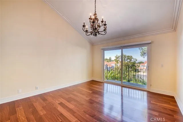 a view of a hallway with wooden floor and chandelier