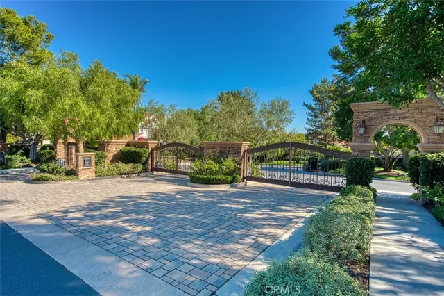 a view of sign board with plants and trees
