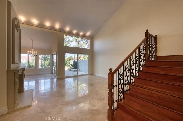 a view of a livingroom with a chandelier fan and windows