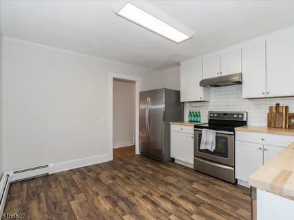 a kitchen with a stove top oven and refrigerator