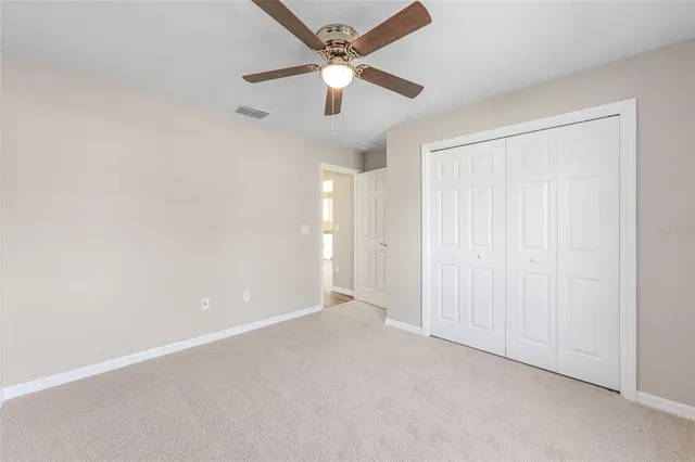 an empty room with chandelier fan
