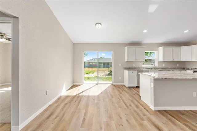 a kitchen with a white wooden cabinets and a window