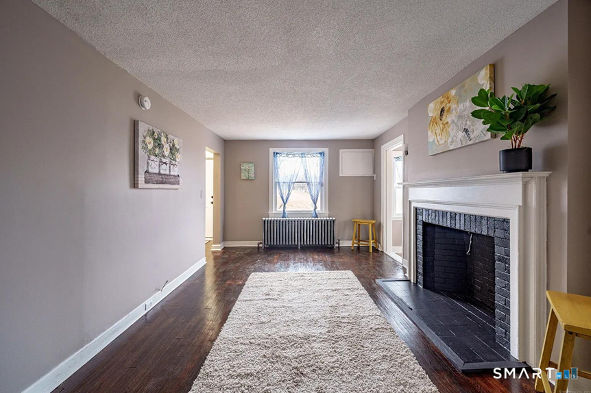 73 Silver Street Middletown, CT 06457 - Photo 4 of 30 a living room with a fireplace and potted plants