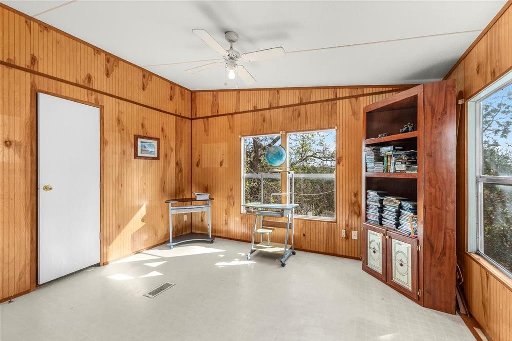 1956 North FM 129 Santo, TX 76472 - Photo 16 of 30 Miscellaneous room with wood walls, lofted ceiling, tile patterned floors, and ceiling fan
