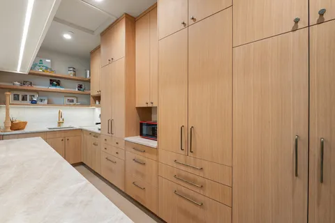 a large white kitchen with granite countertop a sink