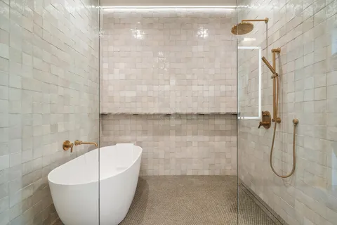 a bathroom with a white bath tub and a shower