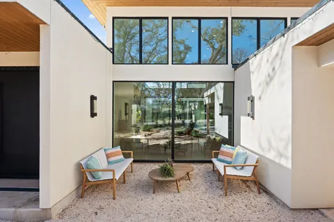a balcony with chairs and with potted plants