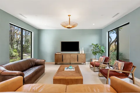 a living room with furniture a flat screen tv and a window